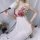 Woman in white suoqing babydoll chemise with red rose lace, holding feather wand.