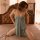 Woman wearing suoqing sexy lace sleep dress with side slit, kneeling on bed in soft lighting.