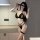 Woman modeling black suoqing sexy lingerie set with cut-out bralette, thong, and thigh garter in modern room.