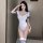 Woman modeling a white sheer bodysuit with navy sailor collar and striped socks, posing indoors.