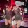 Woman wearing a suoqing sexy v-neck low-cut lace sheer slip dress with full rhinestone embellishment, posing in a dimly lit r...