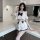 A stylish young woman poses confidently wearing a cute sailor-themed cosplay outfit. the ensemble features a white crop top w...