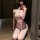A woman poses in a delicate pink suqing sexy kimono-style lingerie set, featuring a tight crop top and ultra-short skirt, acc...