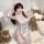 A woman poses in a sweet cherry maid lingerie set featuring lace details and playful design elements, perfect for a charming ...