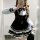A woman poses in a mirror wearing a sweet lace doll collar bow dress, featuring a black and white design with ruffled layers ...