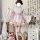 A woman models a sweet lolita maid dress set featuring a floral pattern, ruffled skirt, and apron, perfect for cosplay with a...