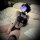 Woman in sweet & spicy female instructor cosplay lingerie set with black stockings, police-themed top, and choker on bed.