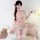 Sweet pink pearl-bikini lingerie set with ruffles, worn by a teen girl with braided hair, posing beside teddy bear and roses.