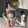 A person wearing a plaid maid costume dress with lace details, posing for a mirror selfie. the outfit features a playful desi...