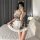 A woman poses in a sweet temptation maid costume set, featuring a plaid dress with lace details and a white apron, perfect fo...
