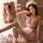 Woman modeling pink sheer sweetheart maid costume with lace trim, heart print lingerie top, mini skirt and fishnet stockings.