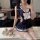 Woman modeling tangdao navy blue sailor-style lingerie set with white bow, lace-up sides, and matching thigh-highs.