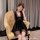 Woman in black lace-trimmed tangdao sleep dress, seated on yellow armchair — modest yet sexy qqn-inspired nightgown.