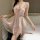 Woman wearing pink lace-trimmed tangdao sensual sleepwear with bow detail, sheer polka-dot overlay, and flirty hemline.
