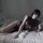 A woman reclines on a bed wearing taoxitangs elegant chinese cheongsam lingerie, featuring a sexy high-waist slit and sheer m...