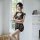 A woman poses elegantly in a black lace bodysuit set featuring an open-crotch design, sheer stockings, and mesh thong, highli...