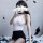 A woman poses with a smartphone, partially obscuring her face as feathers float around her. she wears a white bodysuit paired...