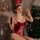 A woman poses in a festive setting, wearing a red velvet bunny costume with lace-up details and fluffy accents, perfect for h...