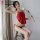 Woman in red vintage chinese-inspired lace belly band sleepwear with embroidered necktie chemise, holding a white rose.