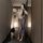 Woman in vintage chinese-inspired lace cheongsam lingerie set with sheer mesh, holding a fan in a modern hallway.