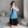 Woman kneeling in blue sheer vintage chinese-inspired lingerie set with side slit, retro qipao style sensual outfit.
