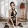 Woman wearing vintage lace cross-breast cheongsam sleep dress with sheer mesh and floral embroidery, sensual bedroom lingerie...
