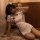 Woman wearing vintage sexy qipao lingerie set - retro chinese-inspired short dress with black trim, posing on floral rug.