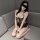 Woman wearing white moonlight sheer mesh lingerie set with lace trim, open-crotch chain detail, and blindfold on gray couch.