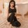 Woman wearing black winnas open-crotch yoga pants and sports bra, sitting on rug near bathtub — seductive fitness lingerie se...