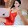 Woman wearing red silky deep v lingerie nightgown set, posing on bed with rose petal, sensual sleepwear for adults.