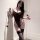 Woman wearing black lace bodysuit with sheer backless design, paired with matching thigh-high stockings and holding a decorat...