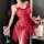 Woman wearing red lace butterfly knot mesh slip dress, holding champagne glass beside floral arrangement.