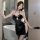 Woman wearing black velvet cheongsam dress with plum blossom lace, high slit, and sensual corset design in modern bathroom.