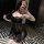 Woman posing in mirror wearing black sheer lace sleepwear set with chest-baring cami and shorts, stylish lounge outfit.