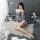 A woman poses elegantly on a fluffy rug, wearing a sleek gray bodycon dress that accentuates her figure. the set features a s...