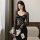Woman wearing black lace bodysuit with sheer sleeves, elegant and form-fitting european style design.