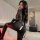 Woman modeling black lace bodysuit with dual zippers and open-crotch design, sheer long sleeves, plus size fit.
