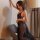 Woman wearing black lace bodysuit with sheer mesh skirt, elegant lingerie set for date night.