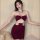 Woman modeling burgundy halter crop top and pencil skirt set with metal ring details.