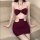 Woman wearing burgundy lace bralette with metal rings and matching pencil skirt, backless halter crop top set.