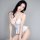 Woman modeling white open-crotch lingerie set with halter neck and ruffled hem, designed for bold confidence.