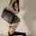 Woman in sexy jk-style lingerie set with sheer top, plaid skirt, and thigh-high stockings holding a black handbag.
