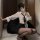 Woman in white blouse and black pencil skirt posing with phone, wearing matching sleepwear set for office or costume.