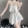 Woman wearing white sheer chiffon lingerie set with ruffled cami top and adjustable straps, paired with matching shorts.