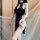 Woman wearing black high-waist split cheongsam lingerie set with sheer veil, reversible seductive bedroom outfit.