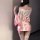 A woman wears a pink satin wuli tu temptation lingerie set, featuring a deep v neckline and floral fox dream design, styled a...