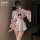 A stylish individual models a cute pink japanese kimono-style sleepwear set, featuring playful patterns and ruffled details, ...