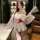 A woman poses elegantly in a sheer kimono-inspired uniform featuring floral prints, designed for a no-remove experience. the ...