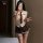 A woman poses with a smartphone, wearing a white blouse, plaid skirt, tie, and stockings, embodying a seductive student unifo...