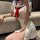 Woman in white sailor-style dress with red bow, featuring cutout sides and lace-up detail, posing on a couch.